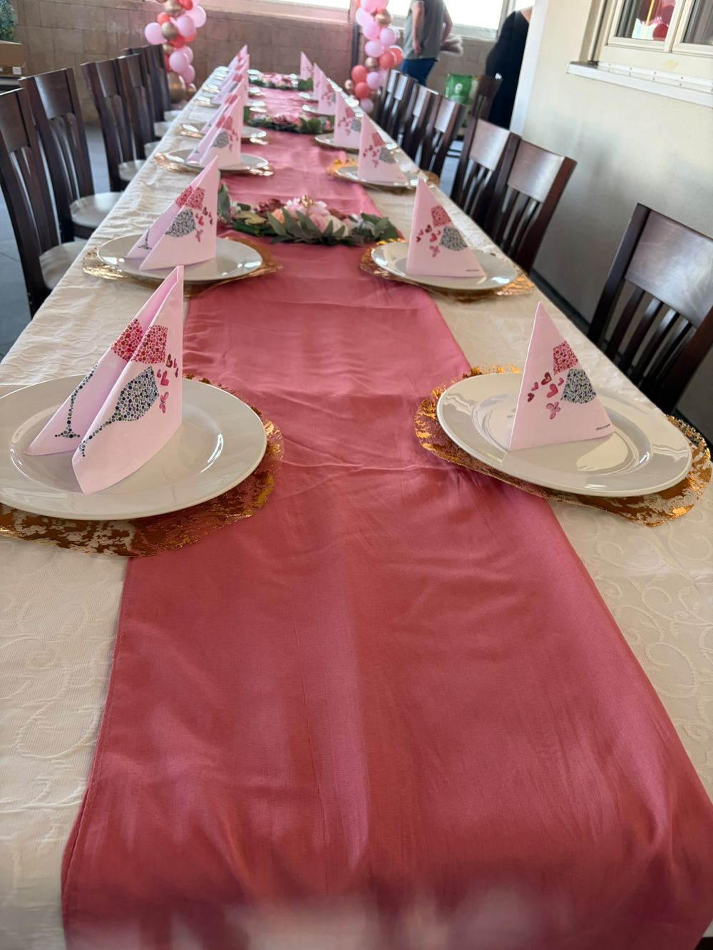 Lange Festtafel mit bordeauxrotem Tischläufer und gefalteten Servietten